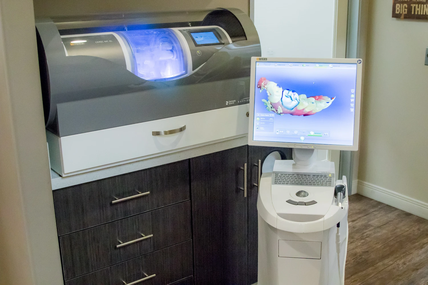 A dental office featuring a computer on a desk and a sink, highlighting a clean and organized workspace.